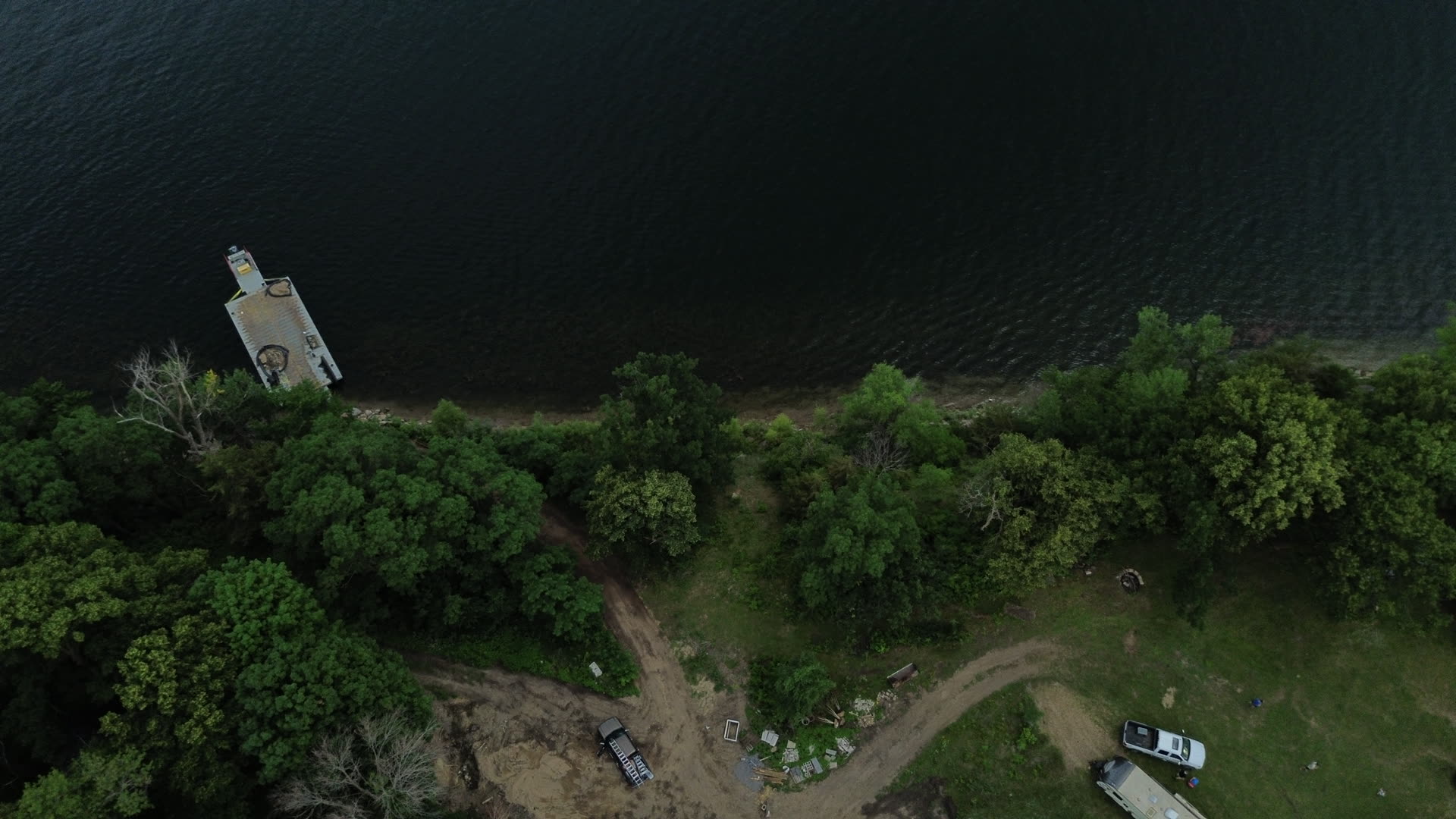 Aerial view of a wooded Minnesota lakeshore parcel with early site work underway